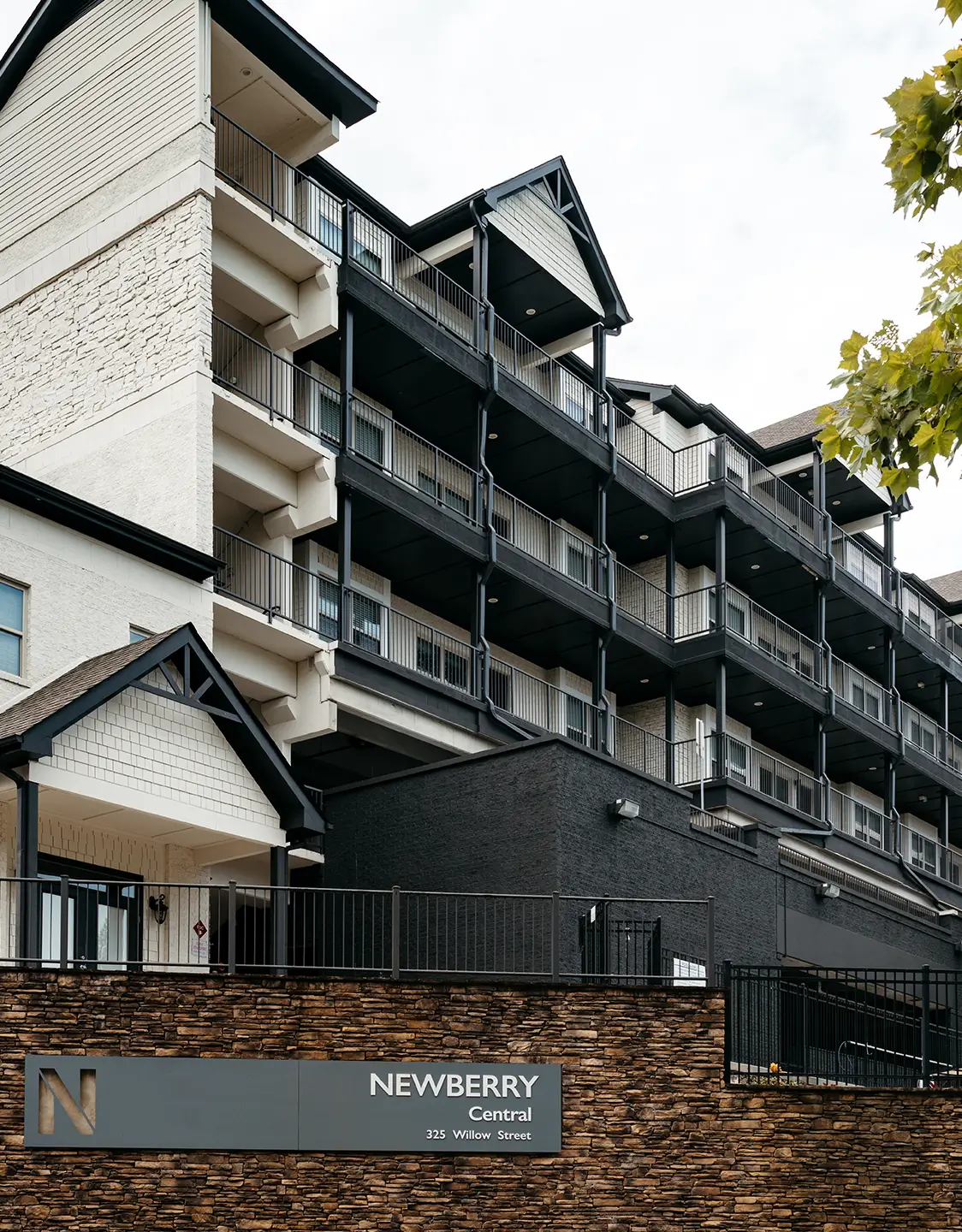 Newberry Athens apartment building with dark balconies and monument sign