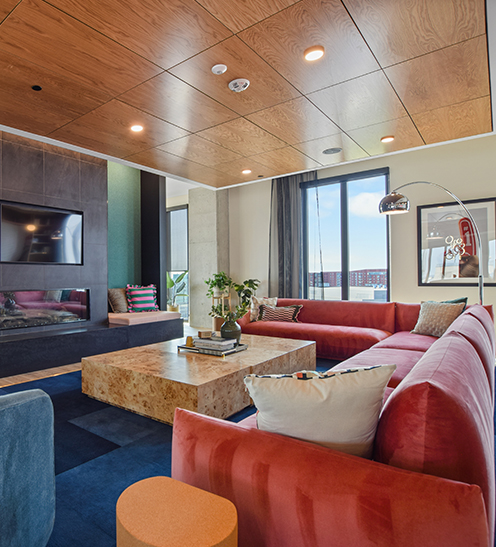 The Rive Columbia lounge with a red sectional sofa and wood ceiling