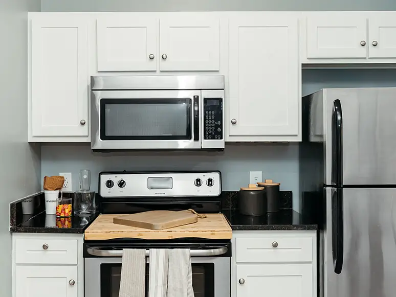 Apartment kitchen with white cabinets and stainless steel appliances