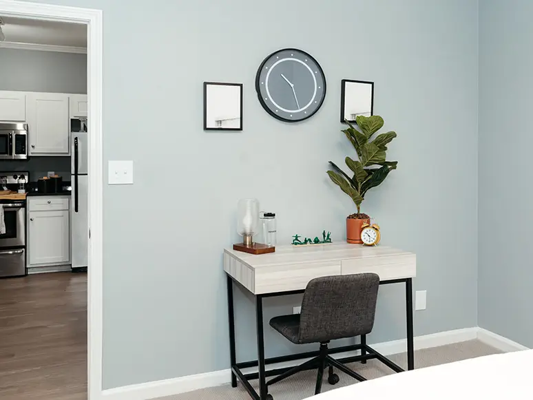 Desk nook with a chair, wall clock, and plant