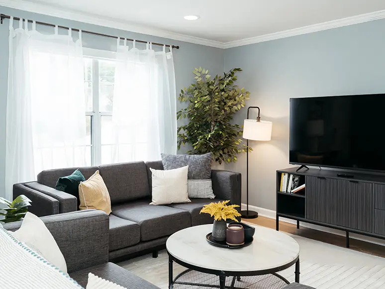 Furnished living room with a gray sectional sofa and wall-mounted TV