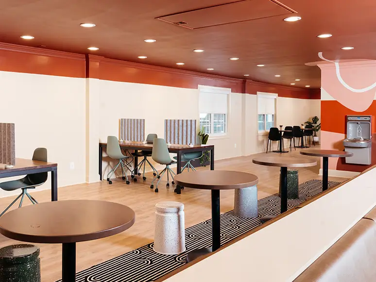 Study lounge with desks, café tables, and a long communal table