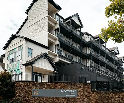 Newberry Athens apartment building with dark balconies and monument sign