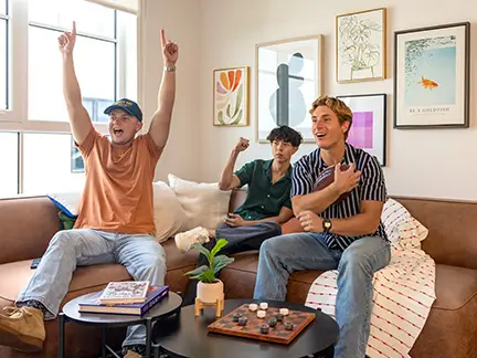 Friends cheering while playing a game in the living room