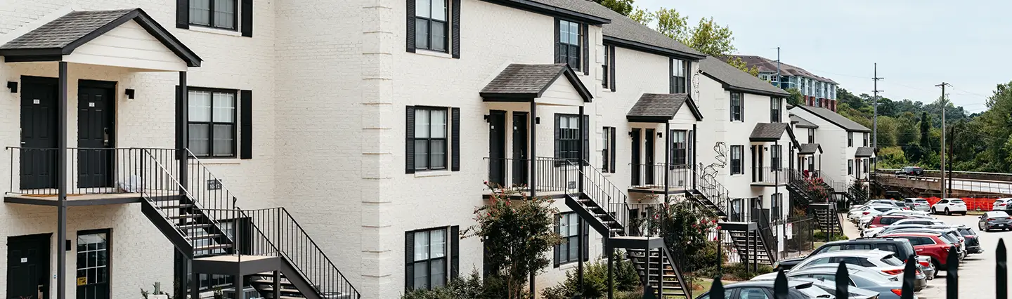 White townhome buildings along a parking lot