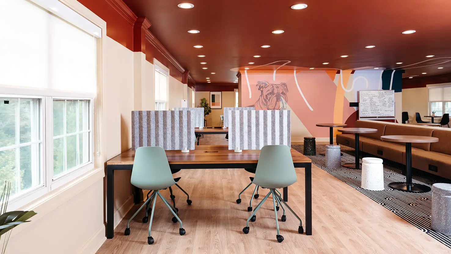 Study area with desks and blue chairs along large windows