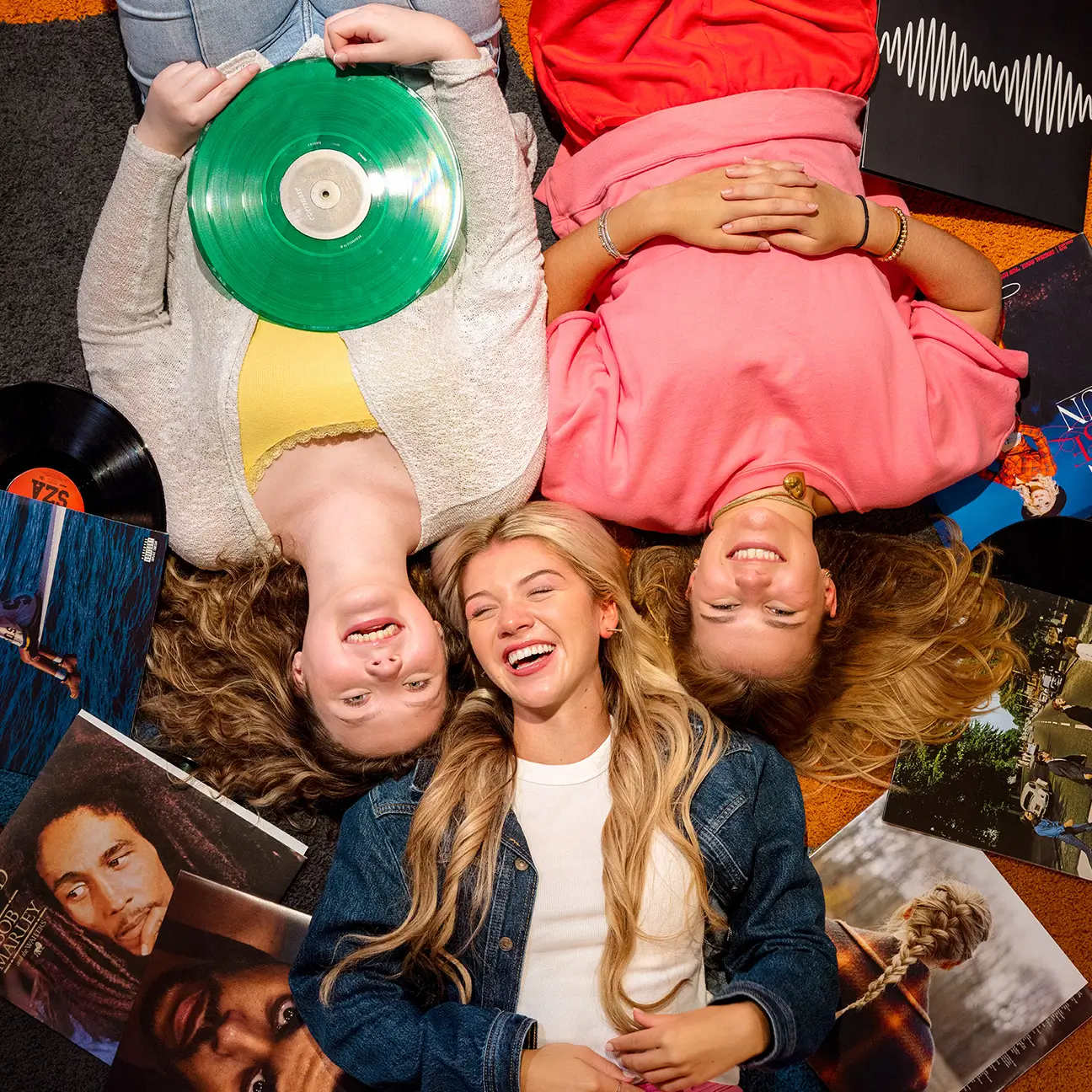 Friends lying on the floor with vinyl records