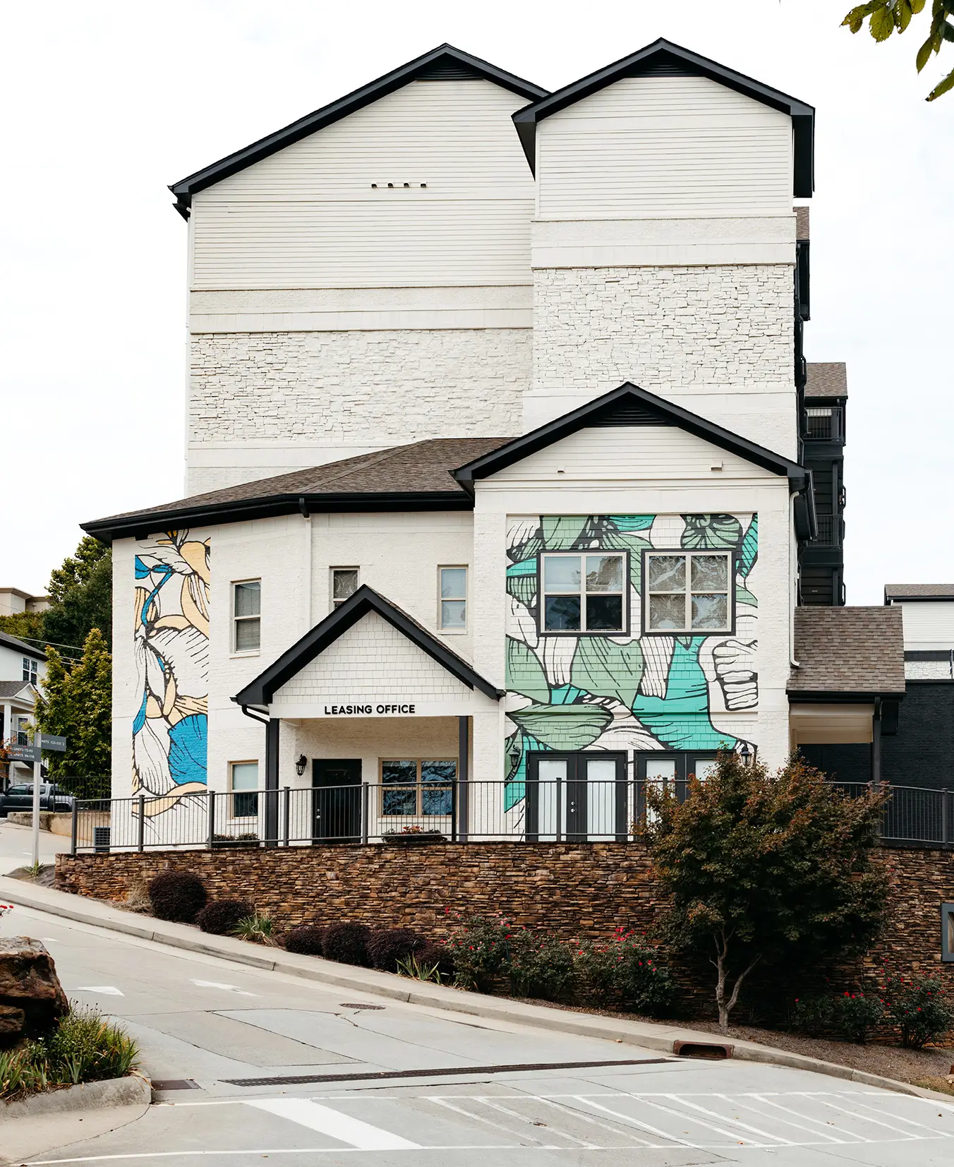 White apartment building with a floral mural on its side