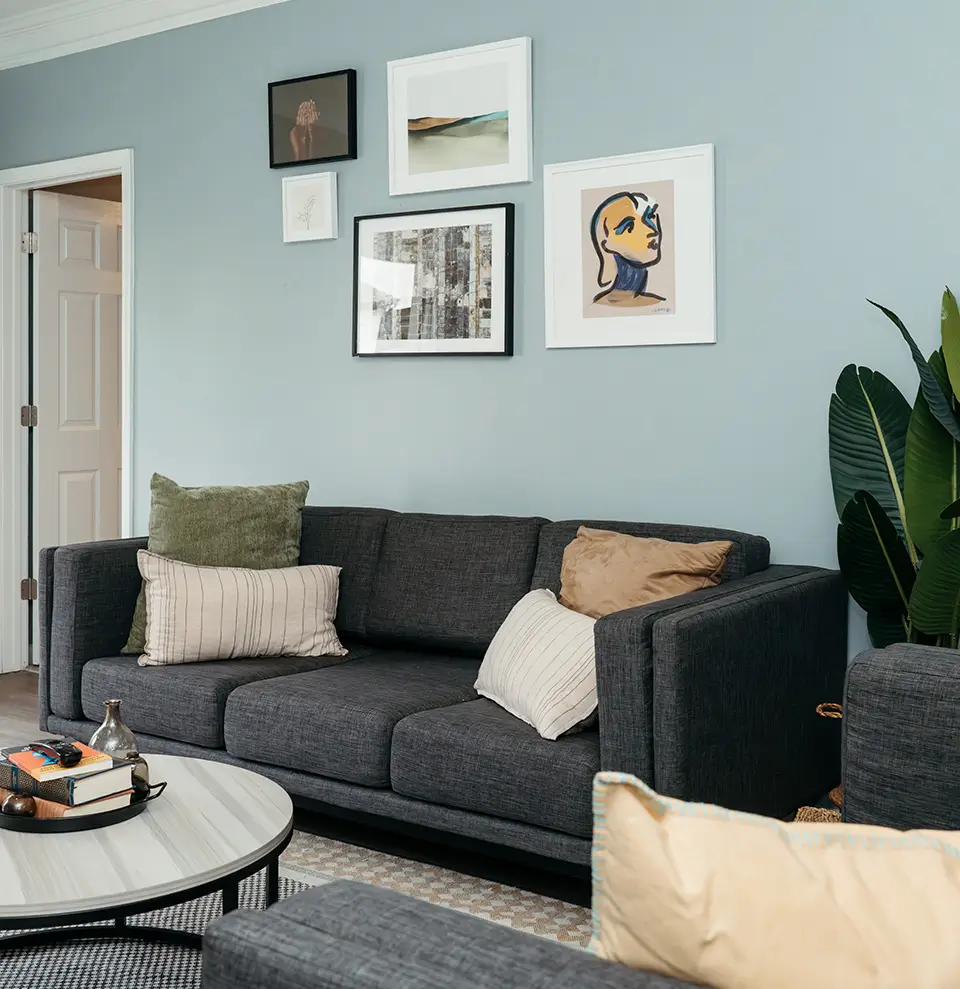 Furnished living room with a gray sofa and gallery wall