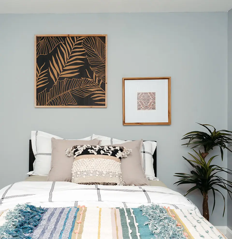 Furnished bedroom with palm leaf art and a plant