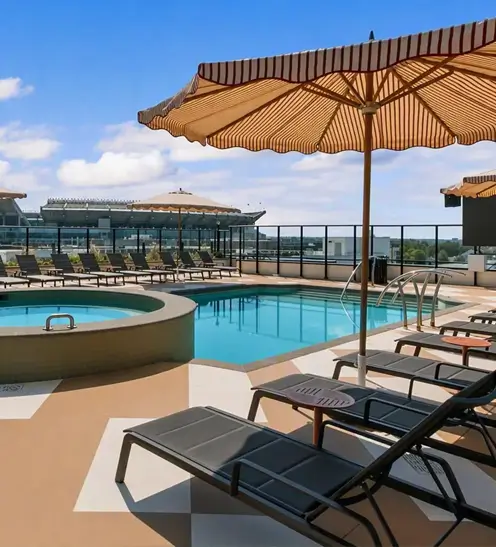 The Rive Tuscaloosa pool and hot tub with an umbrella and lounge chairs